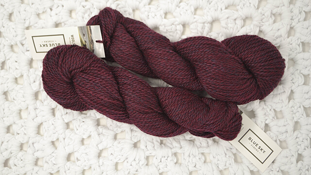 A photo of a skein of Blue Sky Fibers Woolstok Worsted in Deep Velvet colorway.