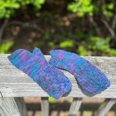 Fingerless mitts hand knitted with blue and purple yarn.